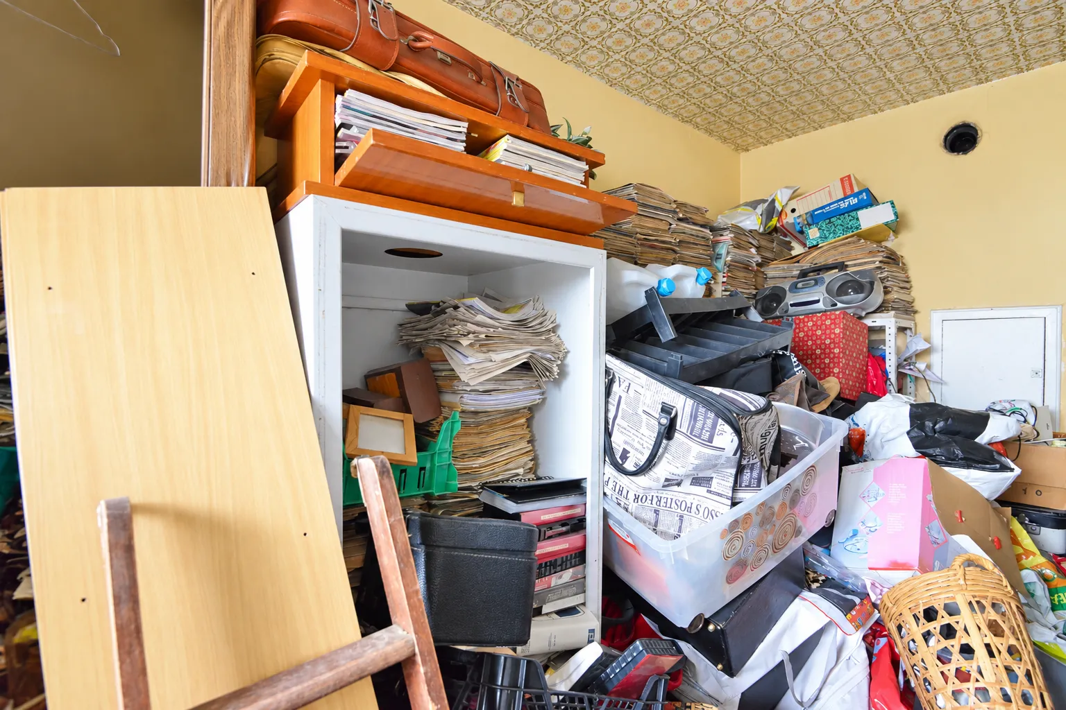 Pièce remplie de meubles, cartons et papiers avant débarras