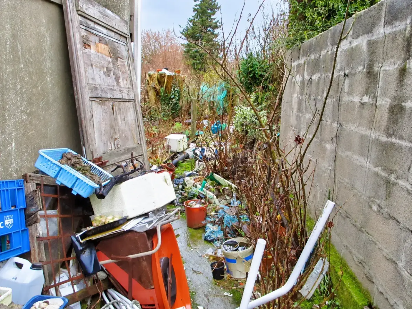 Jardin encombré d'objets et de matériel entassés