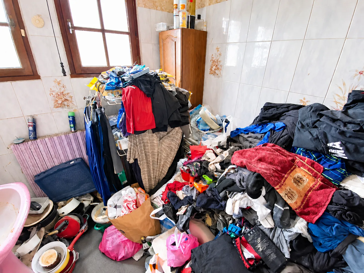 Pièce envahie de vêtements entassés, situation d'accumulation d'objets